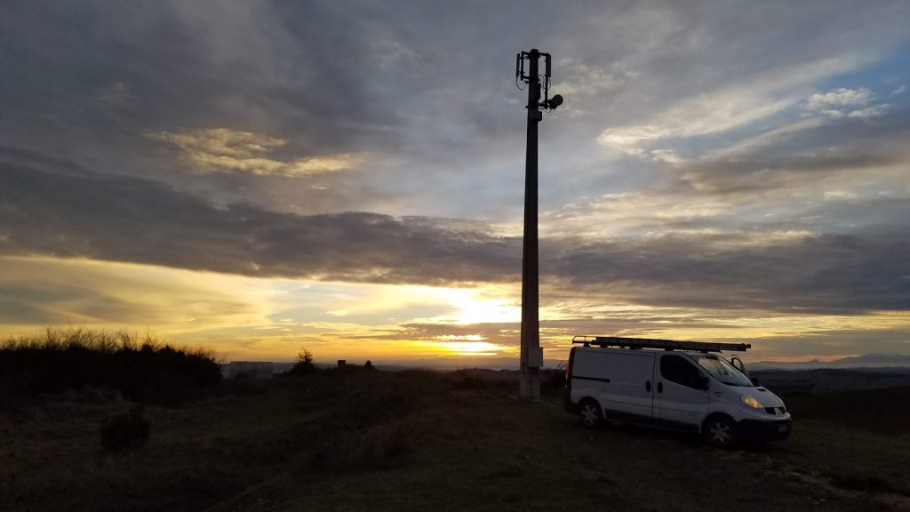 Véhicule utilitaire CF31 au pied d'un mât télécom au coucher du soleil
