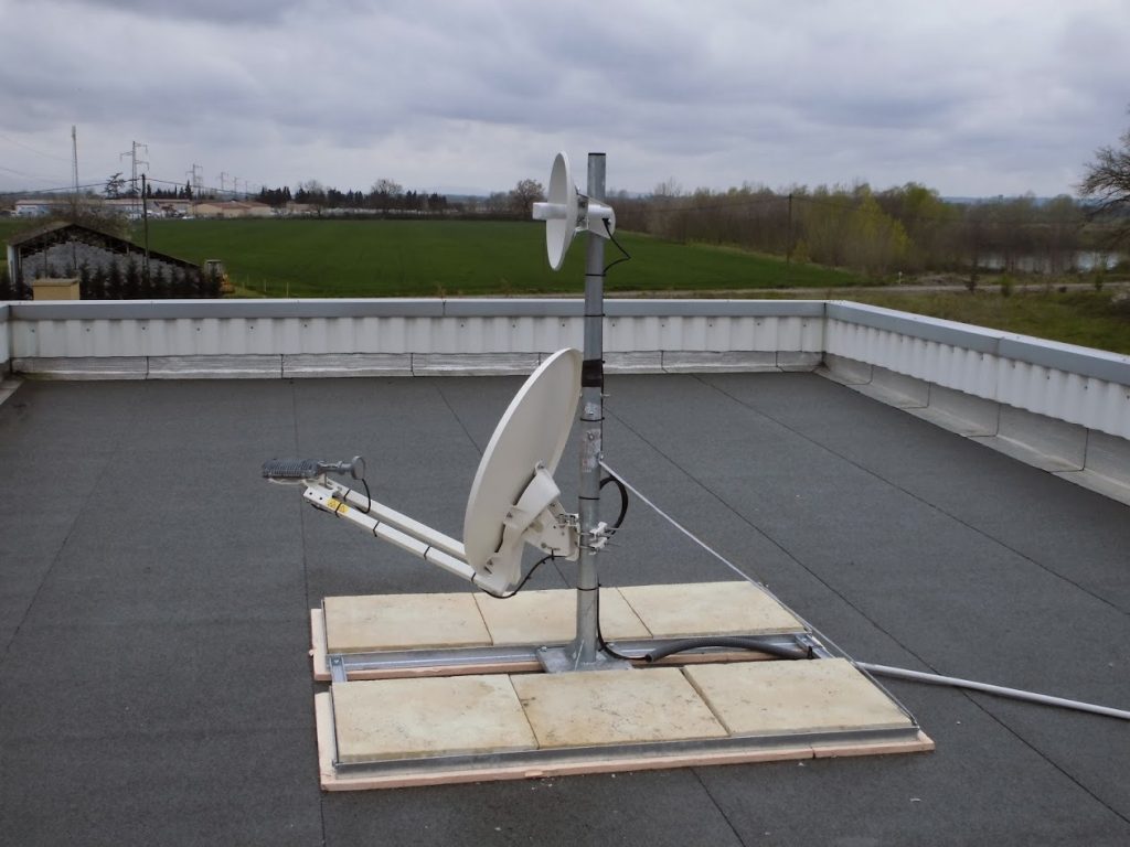 Mât avec parabole satellite et antenne de liaison sur toiture-terrasse lestée
