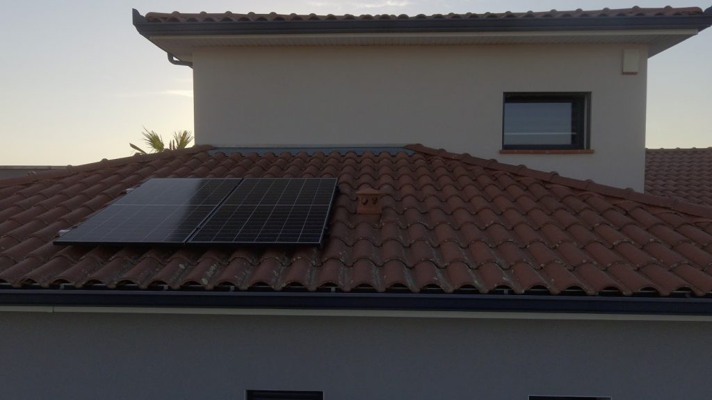 Toiture tuile avec deux panneaux photovoltaïques vus par drone, raccordement électrique