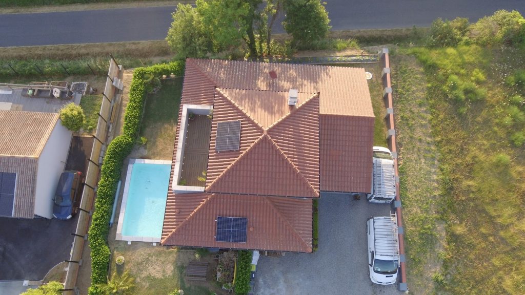 Vue aérienne toiture avec deux implantations de panneaux solaires et piscine