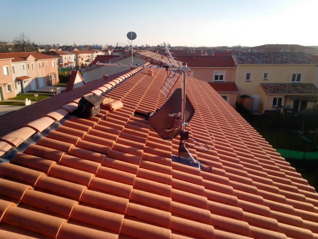 Parabole satellite installée en faîtage de toiture dans un lotissement pavillonnaire