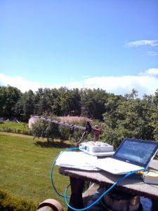 Technicien réglant une antenne extérieure et testant la connexion Internet sur ordinateur portable