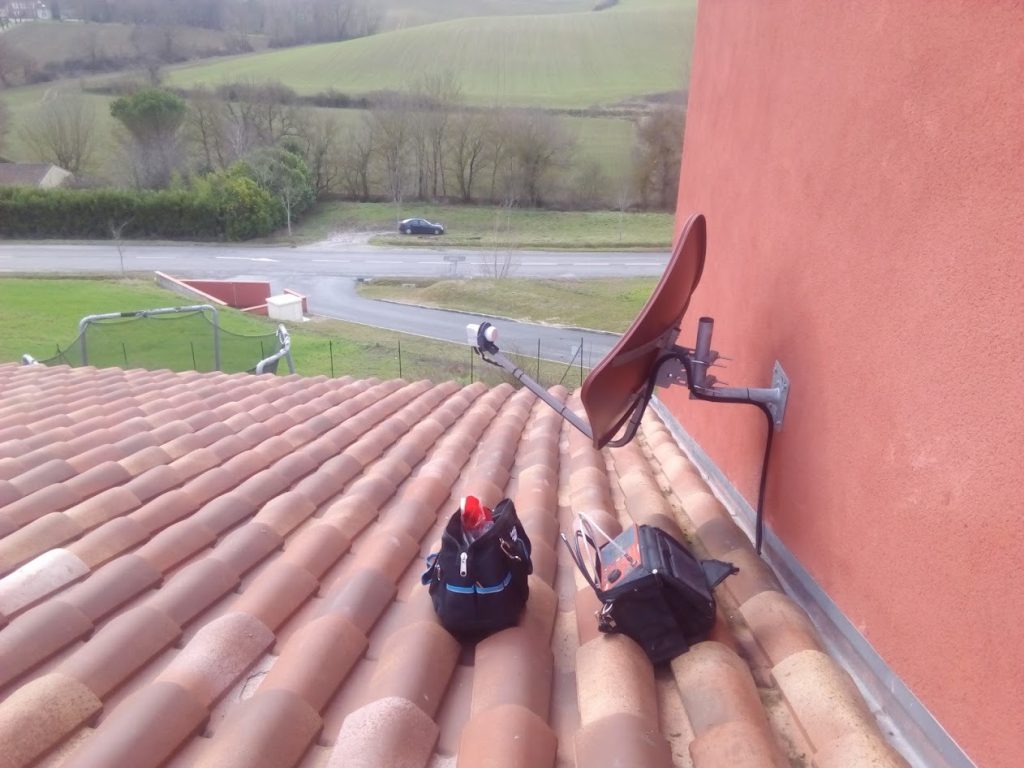 Parabole satellite fixée en façade avec réglage de réception depuis la toiture