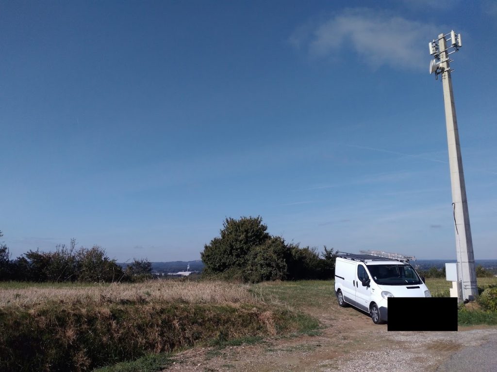 Véhicule technique stationné au pied d'un pylône télécom rural
