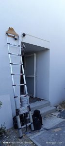 Caméra extérieure fixée sous auvent au-dessus d'une porte d'entrée protégée des intempéries