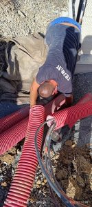 Pose de fourreaux rouges en tranchée pour raccordement électrique basse tension enterré